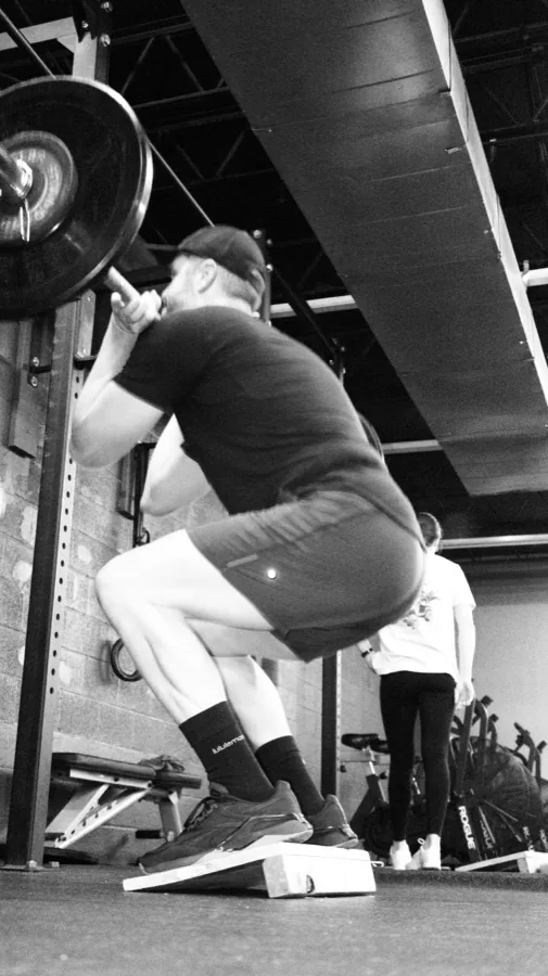 A Vickery Athletics member squatting at the rack